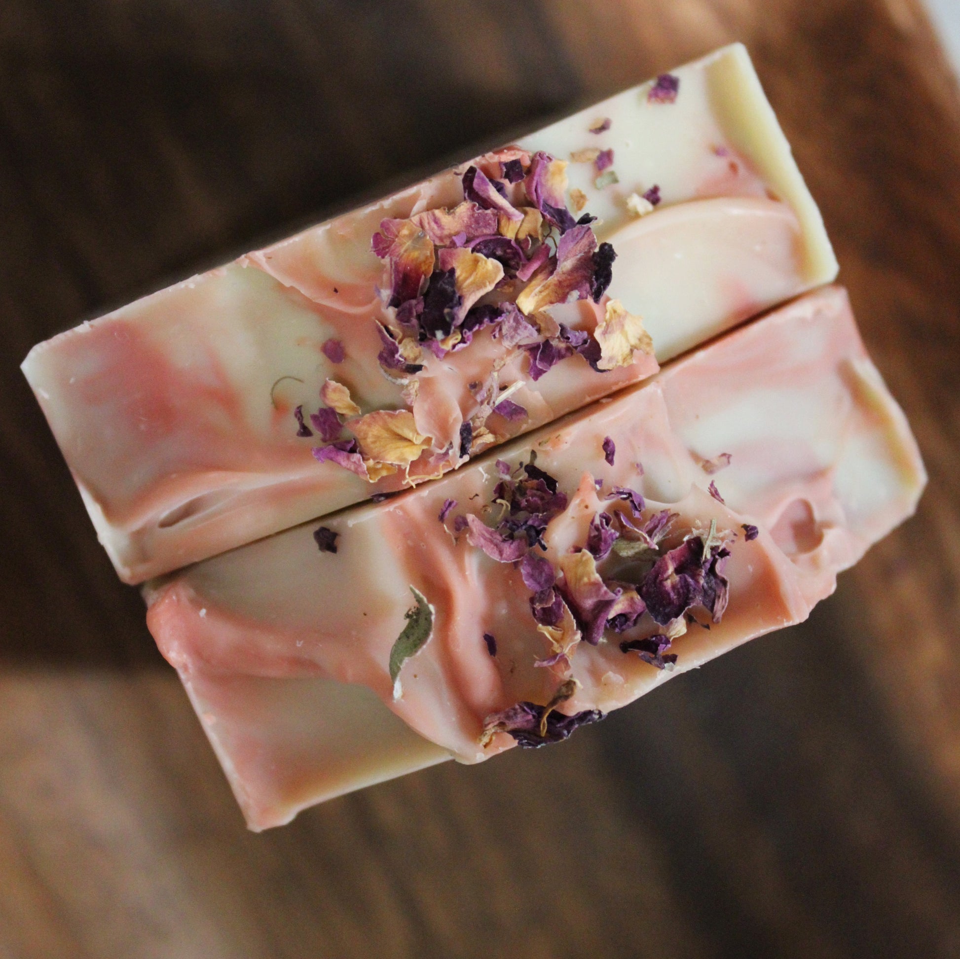 All natural Lavender Rose soap photographed from above embellished with rose petals on top. 
